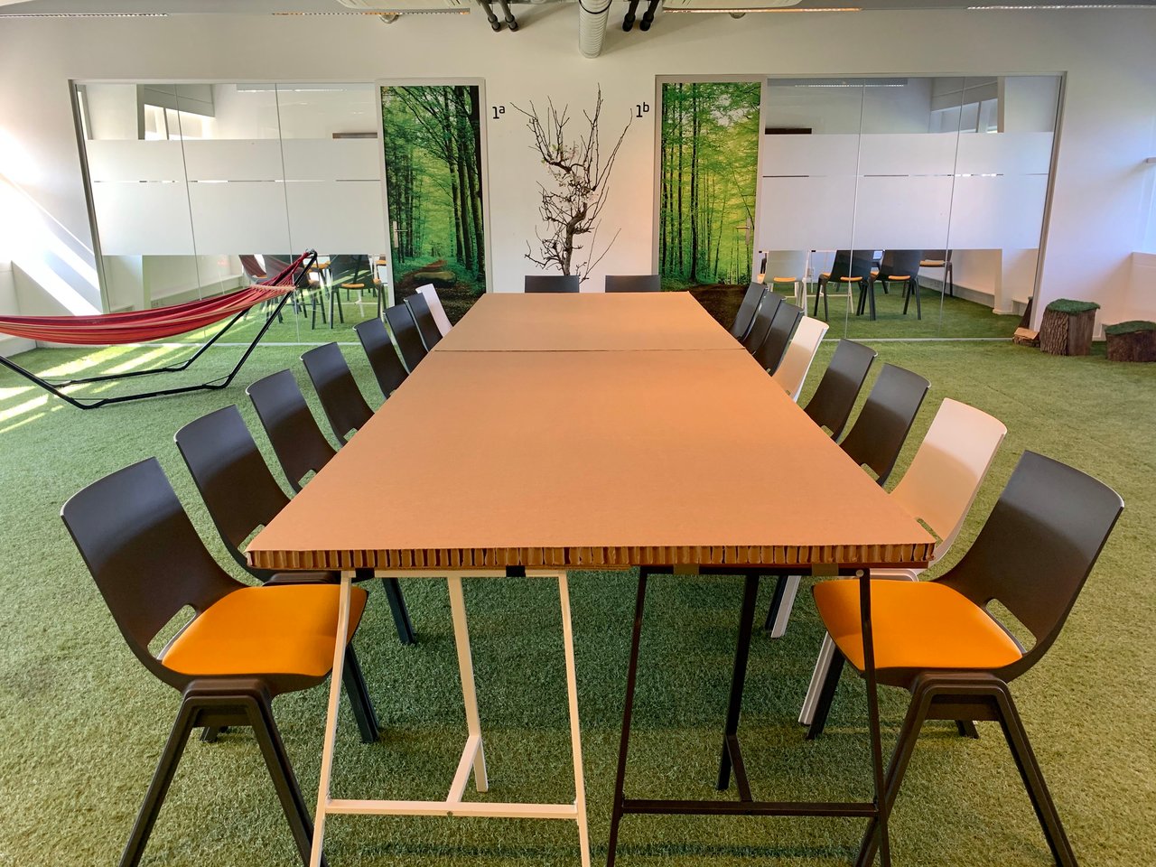 Meeting Space 1 - Vergadertafel - Break-out rooms - Stoelen - Kartonnen Tafel - Kunstgras - Hangmat - DUS De Utrechtse Stadsvrijheid