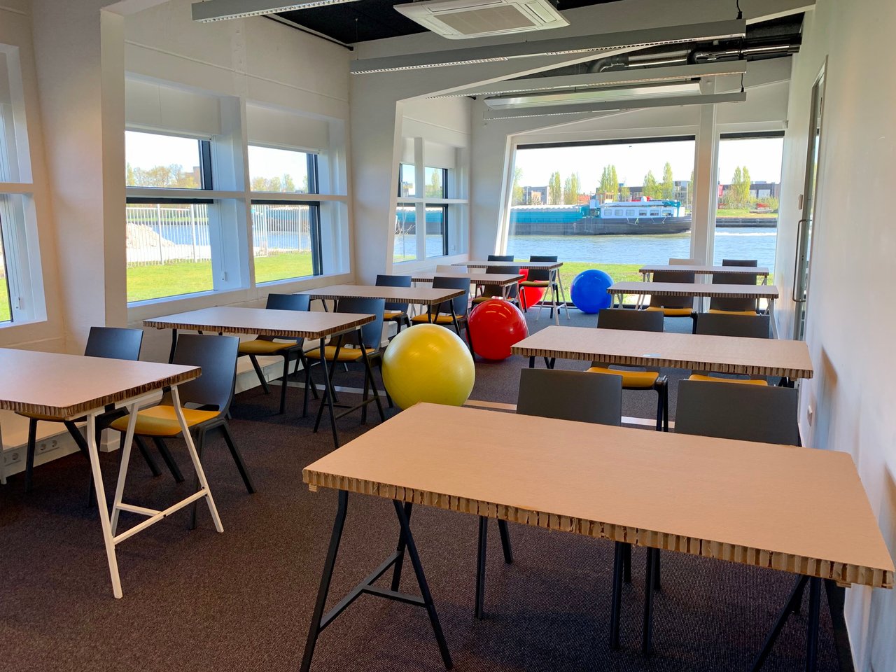 Meeting Space - Space 4 - Zaal 4 - Opstelling - Schoolopstelling - Kartonnen tafels - Yogaballen - Kanaal - Uitzicht - Water - Boot - Schepen - DUS De Utrechtse Stadsvrijheid